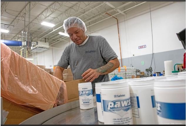 Juan Rivera, an employee at Safetec of America in Buffalo, works near the company's p.a.w.s. Antimicrobial Hand Wipes products, which are formulated with 66.5% ethyl alcohol to kill 99.99% of germs, according to Safetec literature. (file photo) MARK WEBSTER