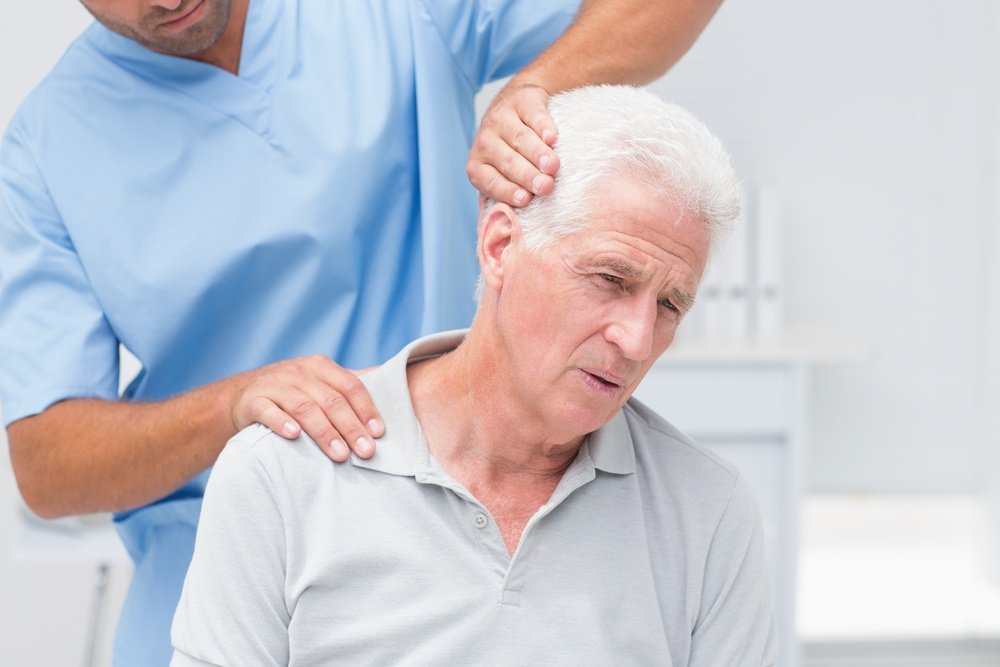 Physiotherapist giving physical therapy to senior male patient in clinic.jpeg
