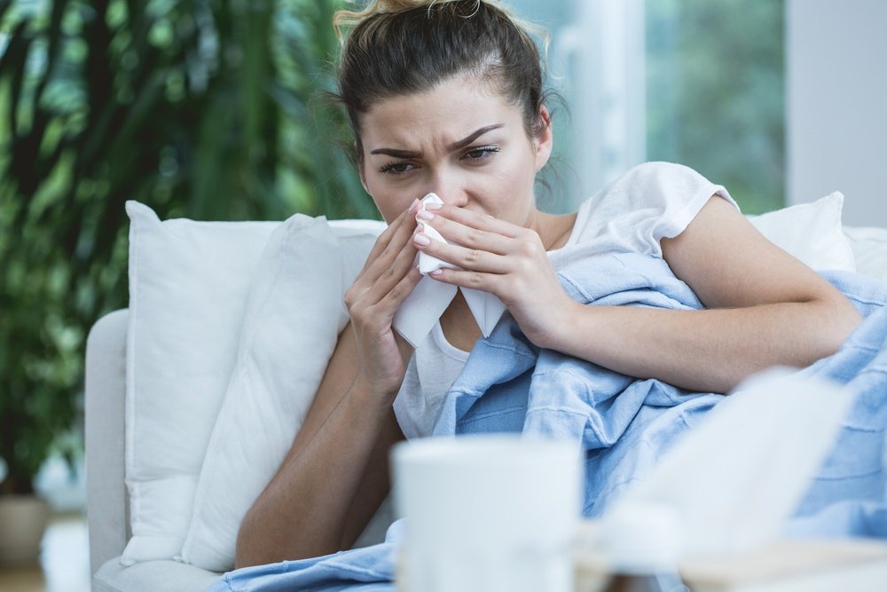 Sick woman with runny nose lying in bed-1